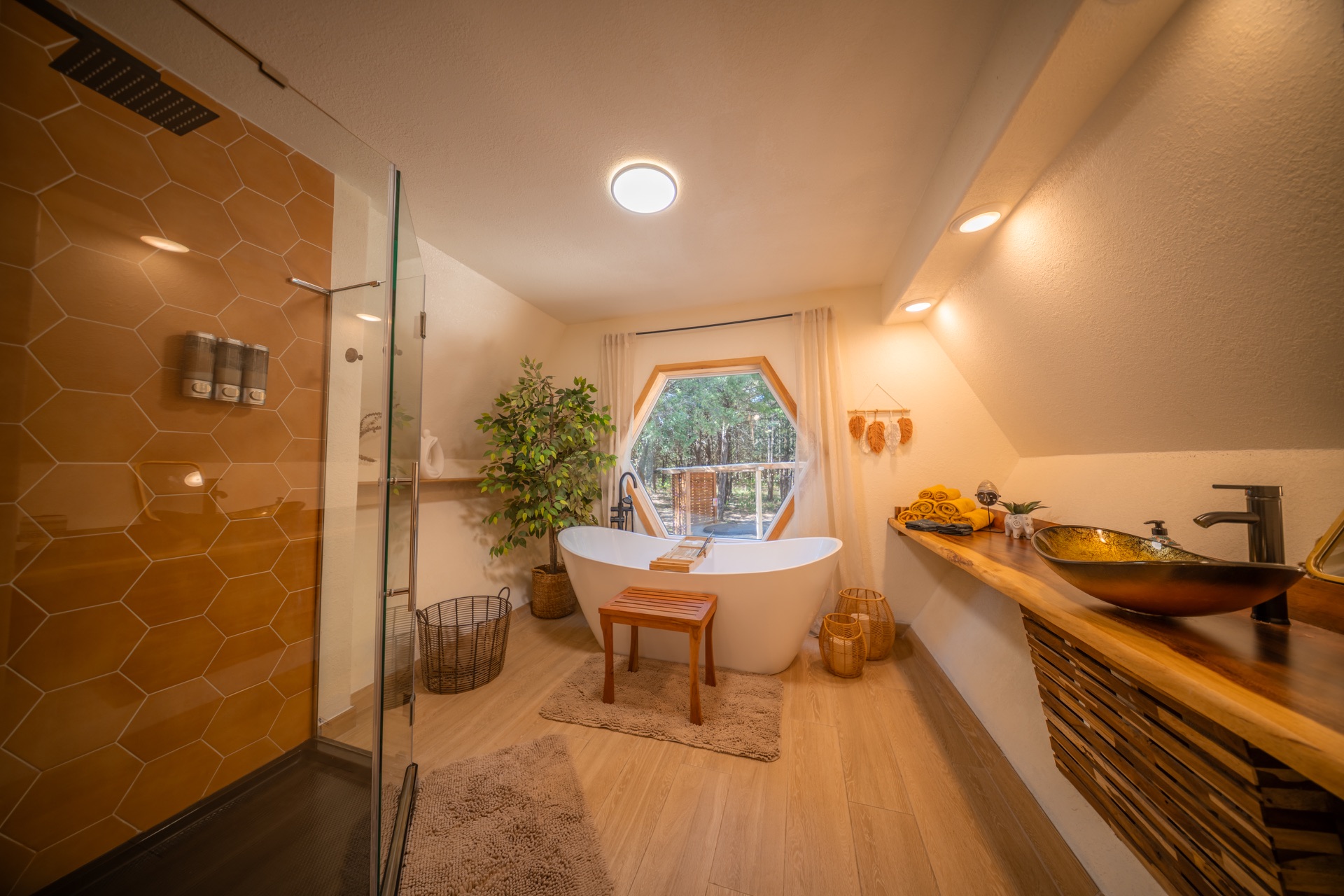 HoneyHive bathroom with a freestanding bathtub, hexagonal window, and glass shower