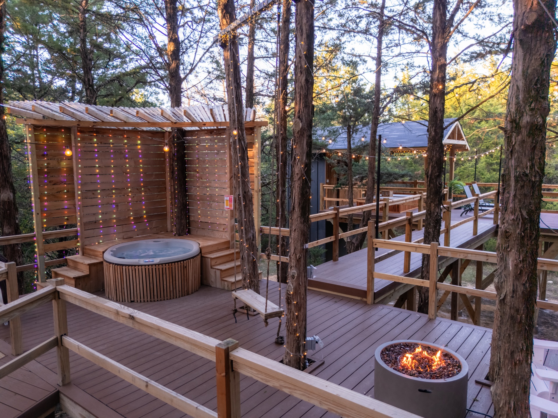 TreeTopia woodland deck with a hot tub, walkways, and fire pit